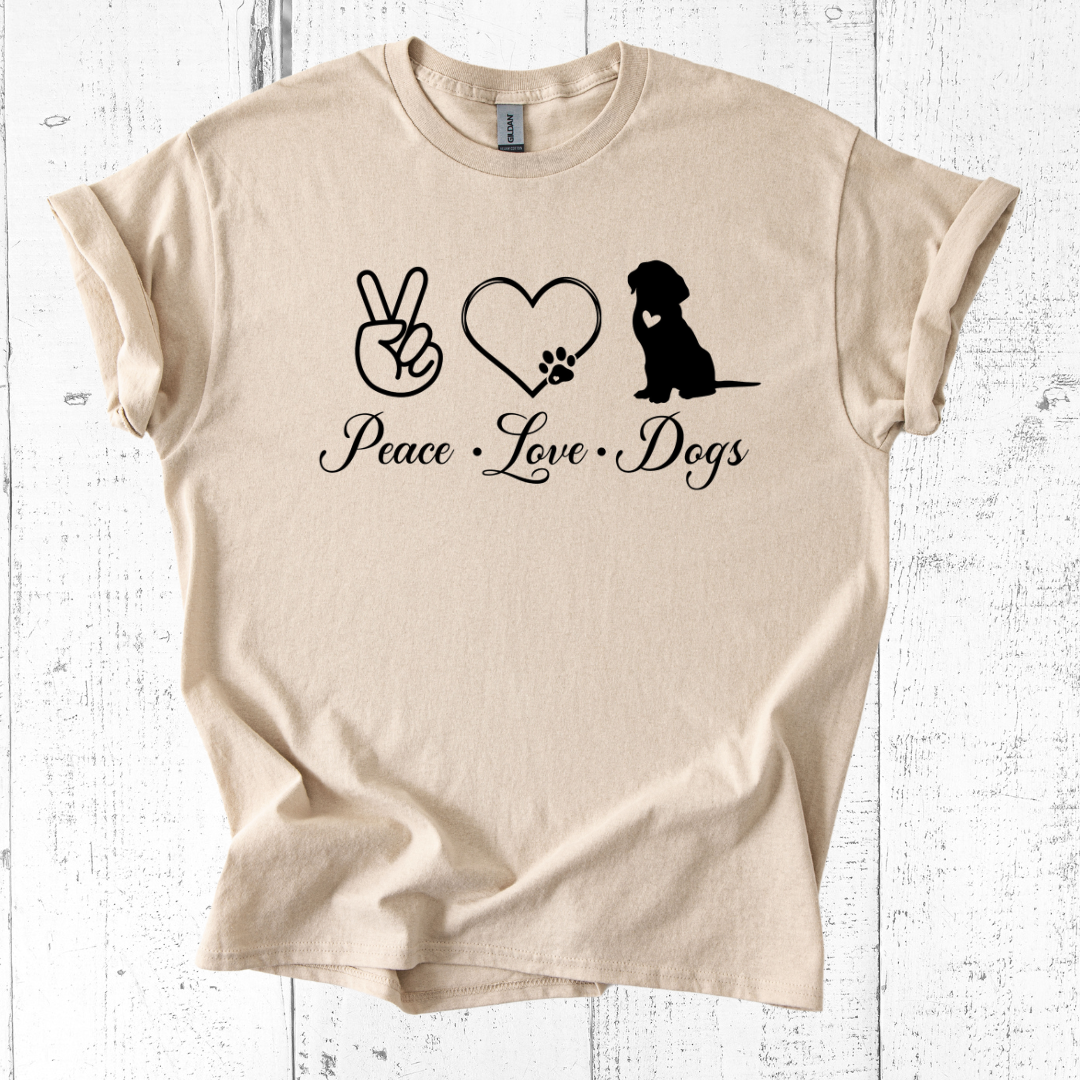 Beige t-shirt with 'Peace Love Dogs' text and graphics on a white wooden background