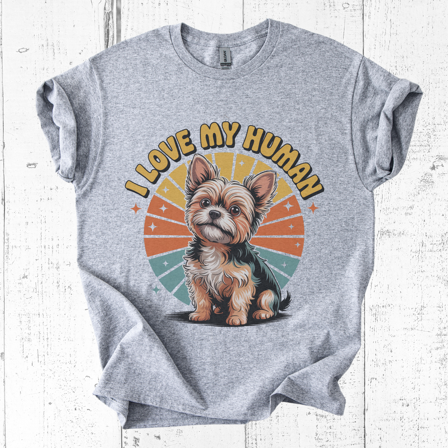 Gray t-shirt with a dog graphic and 'I Love My Human' text on a white wooden background
