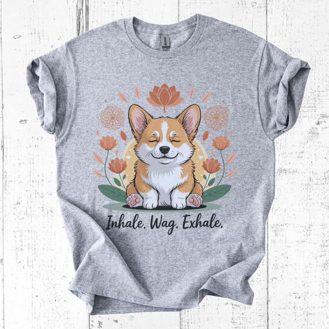 Gray t-shirt with a corgi graphic and 'Inhale. Wag. Exhale.' text on a wooden surface