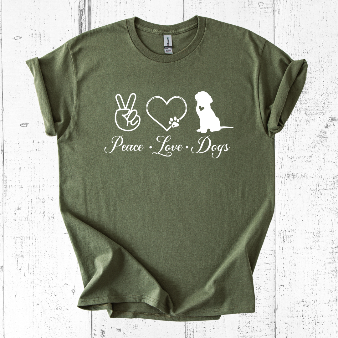 Green t-shirt with 'Peace Love Dogs' design on a white wooden surface