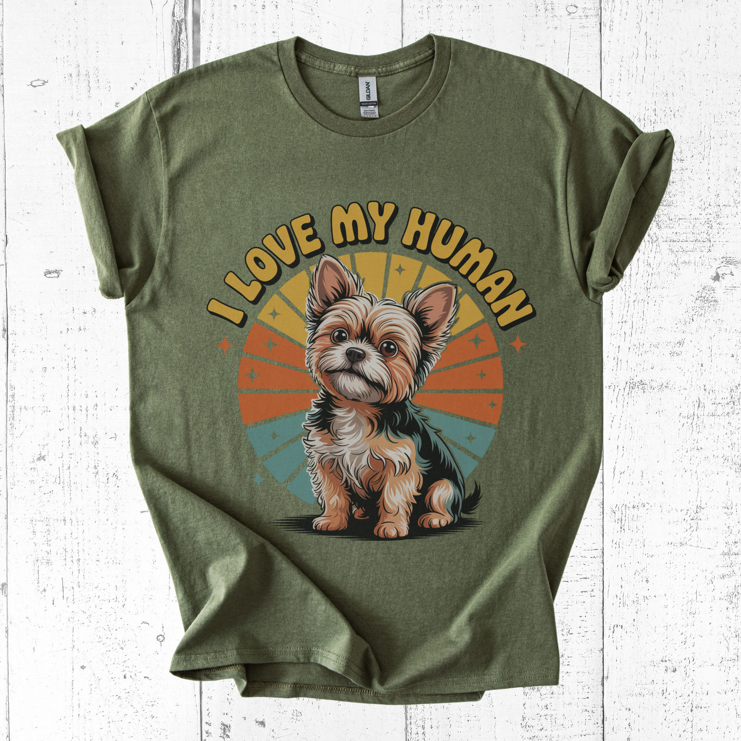 Green t-shirt with a dog graphic and 'I Love My Human' text on a white wooden surface