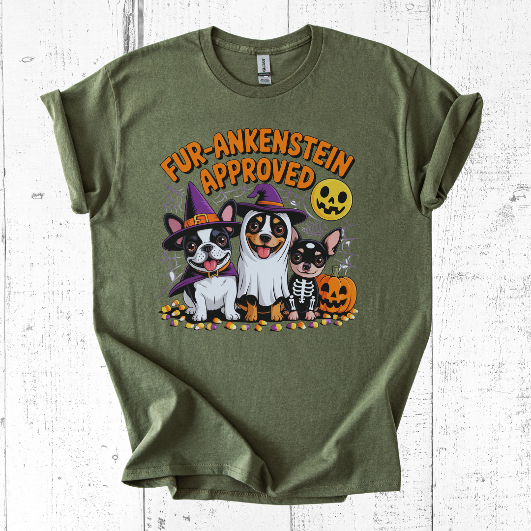 Green t-shirt with Halloween-themed design featuring dogs in costumes on a white wooden background.