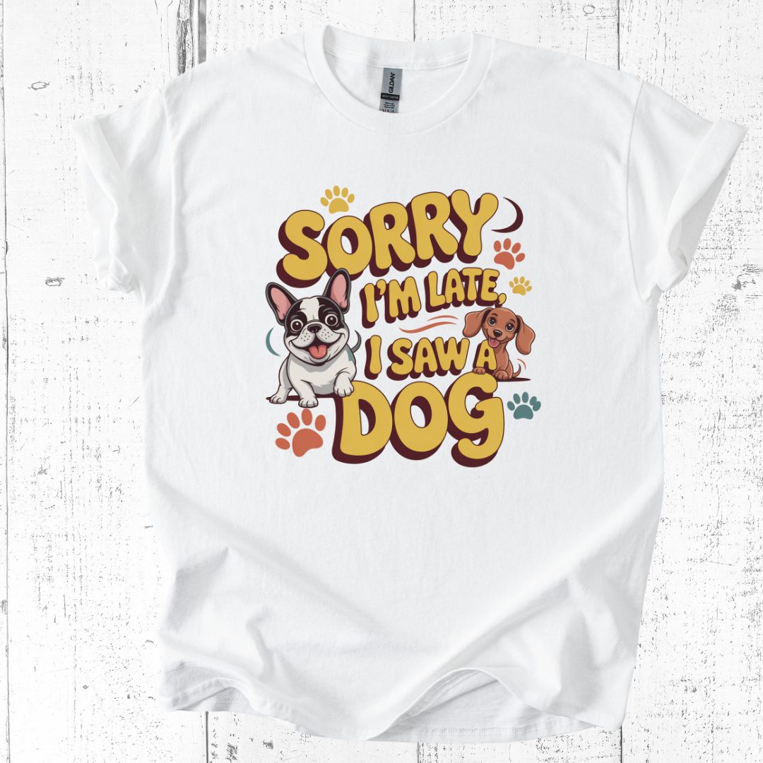 White t-shirt with 'Sorry I'm Late, I Saw a Dog' graphic on a wooden surface