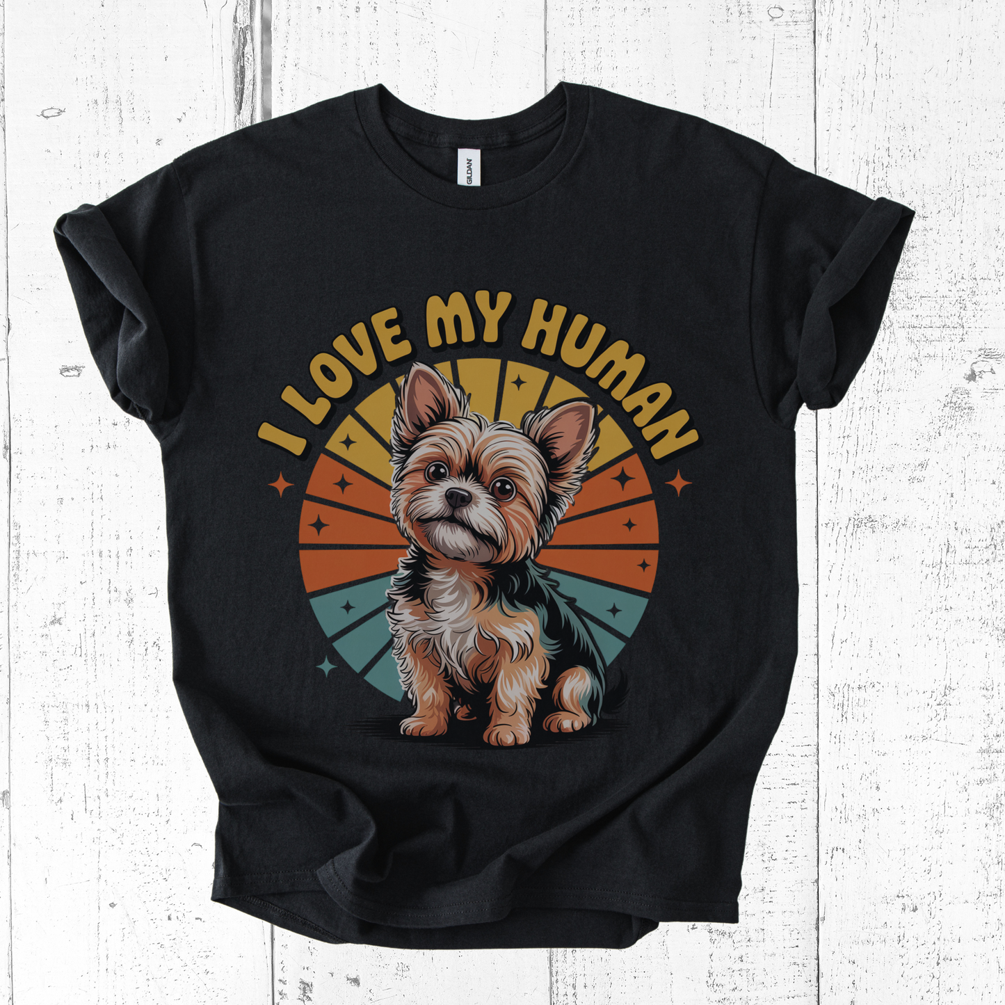 Black t-shirt with a dog graphic and 'I love my human' text on a wooden surface