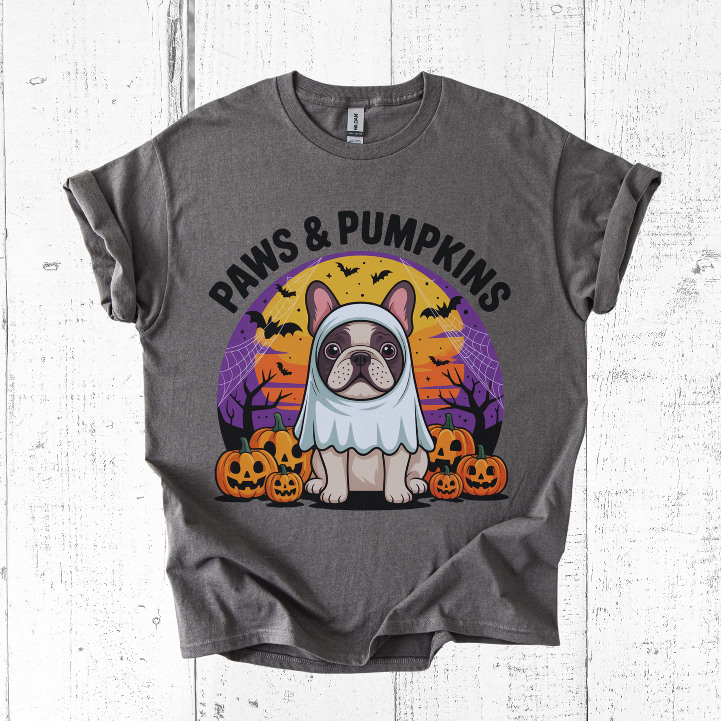 Gray t-shirt with a dog in a costume and 'Paws & Pumpkins' text on a white wooden background