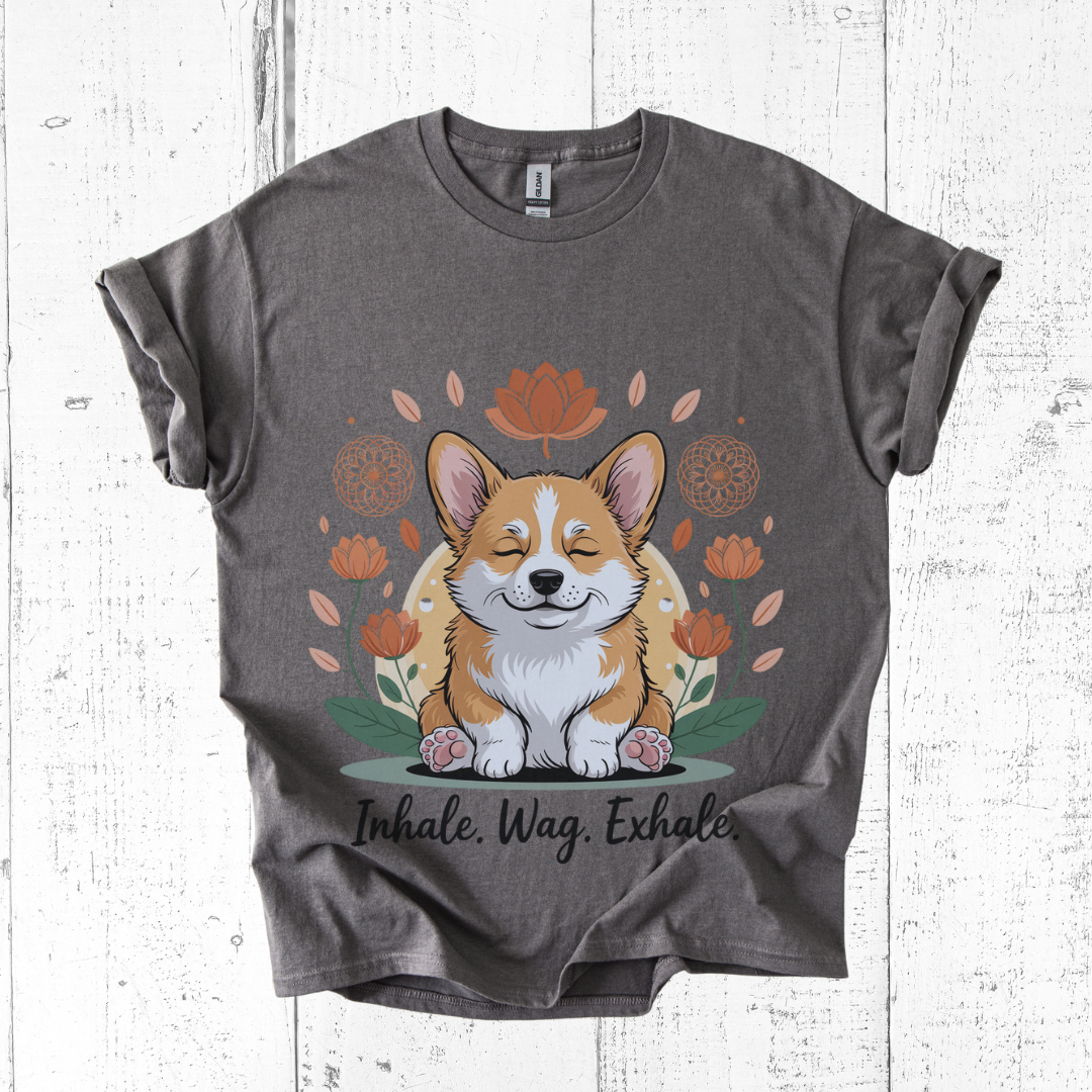 Gray t-shirt with a corgi graphic and 'Inhale. Wag. Exhale.' text on a white wooden background