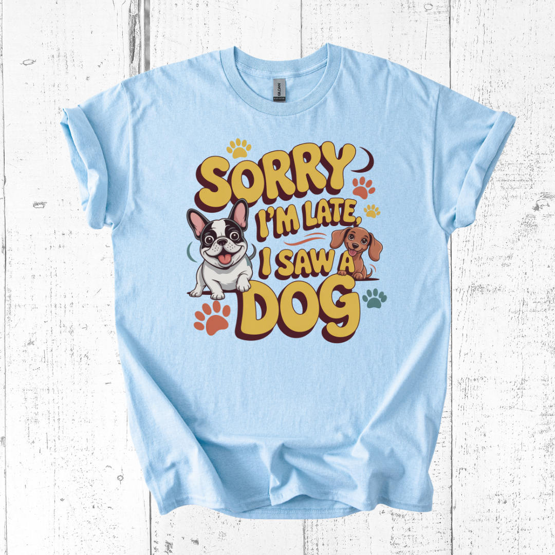 Light blue t-shirt with cartoon dogs and text on a white wooden background