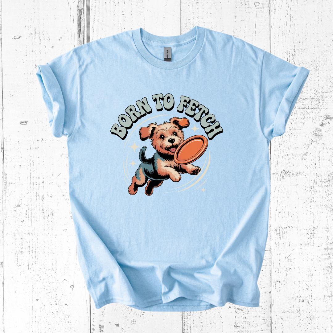 Light blue t-shirt with a dog graphic and 'Born to Fetch' text on a wooden surface