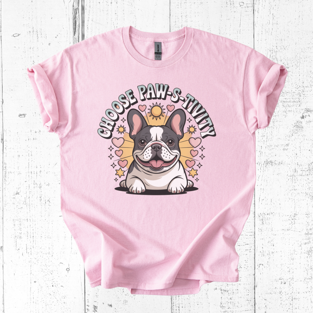 Pink t-shirt with a dog graphic and text on a white wooden background