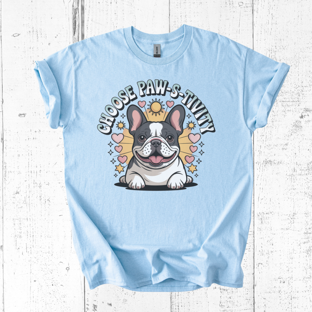 Light blue t-shirt with a cartoon dog and text on a wooden surface