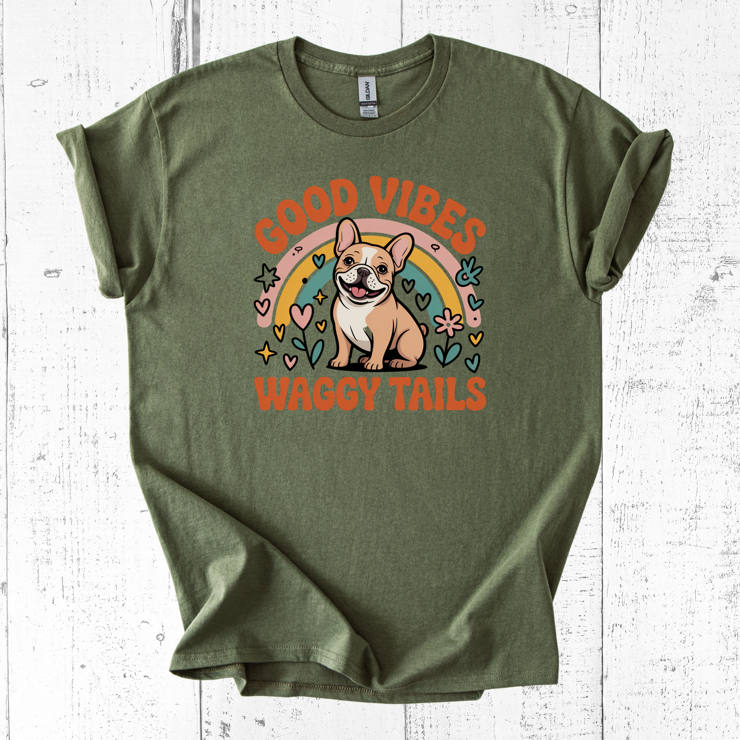Green t-shirt with a dog graphic and 'Good Vibes Waggy Tails' text on a white wooden background