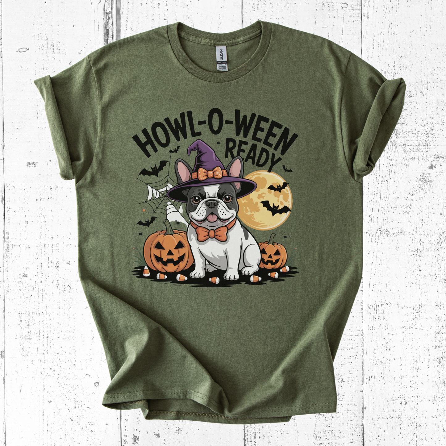 Green t-shirt with Halloween-themed design featuring a dog in a witch hat and pumpkins on a white wooden background.