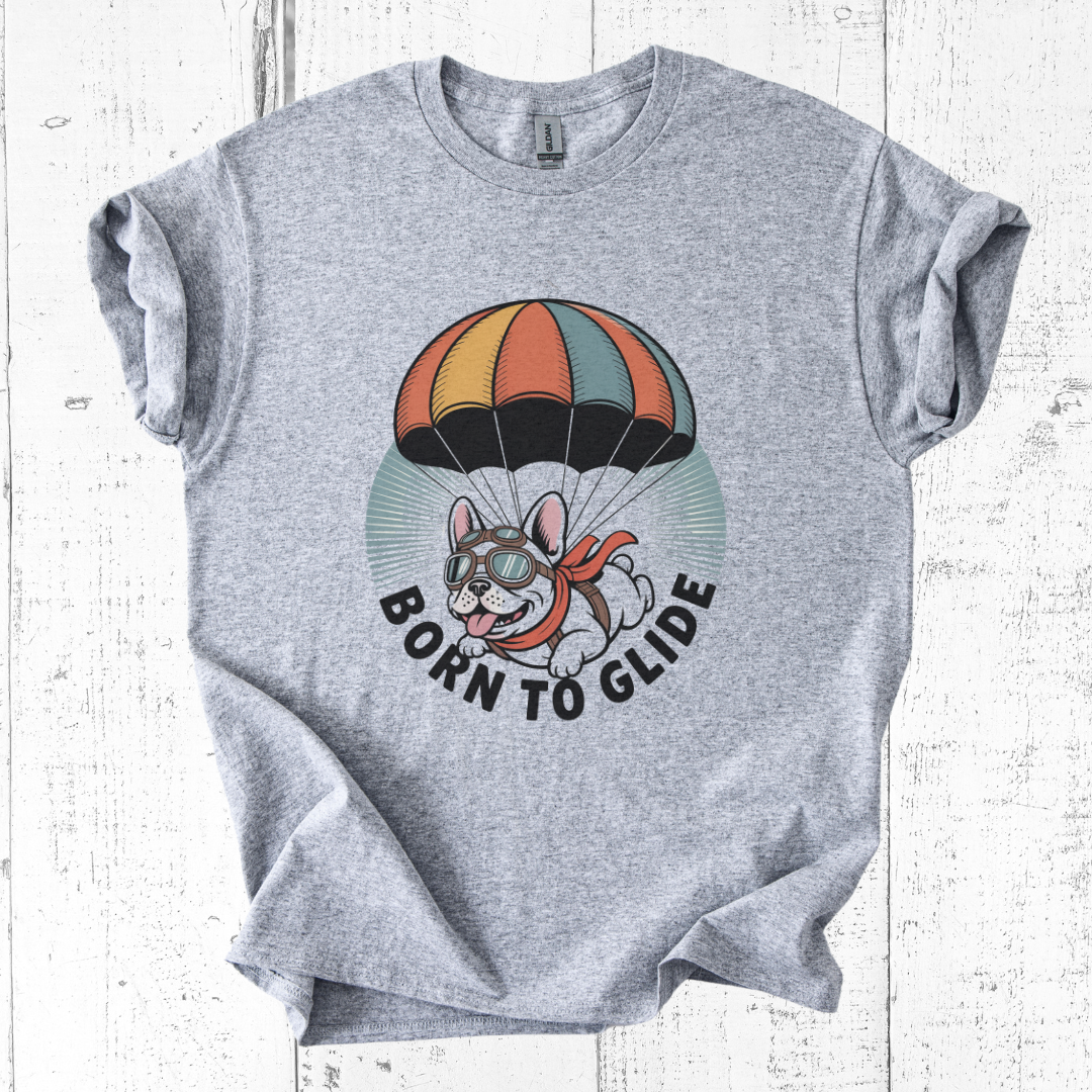 Gray t-shirt with a graphic of a dog with a parachute and 'Born to Glide' text on a white wooden background.