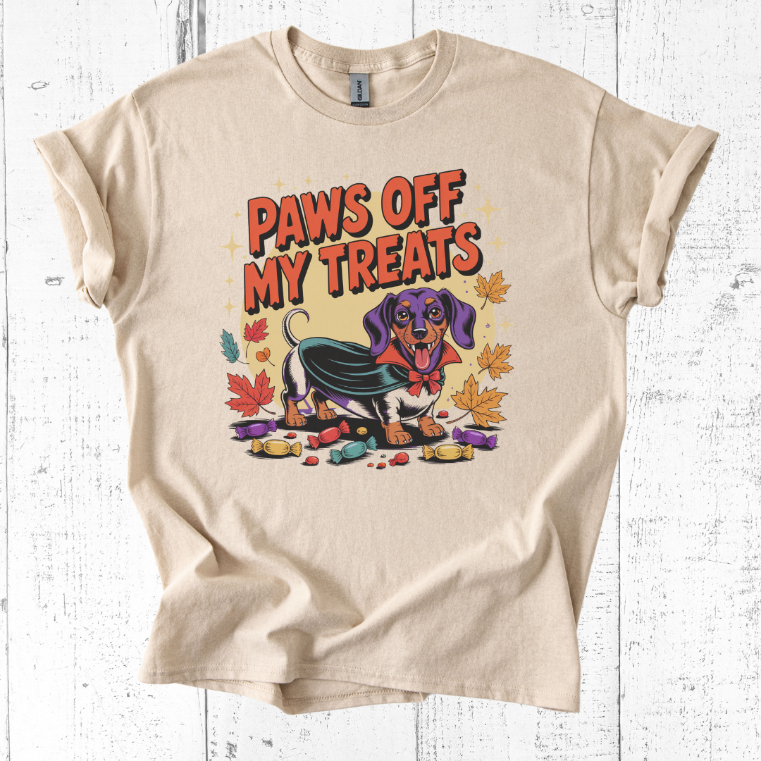 Beige t-shirt with a dachshund graphic and 'Paws Off My Treats' text on a white wooden background