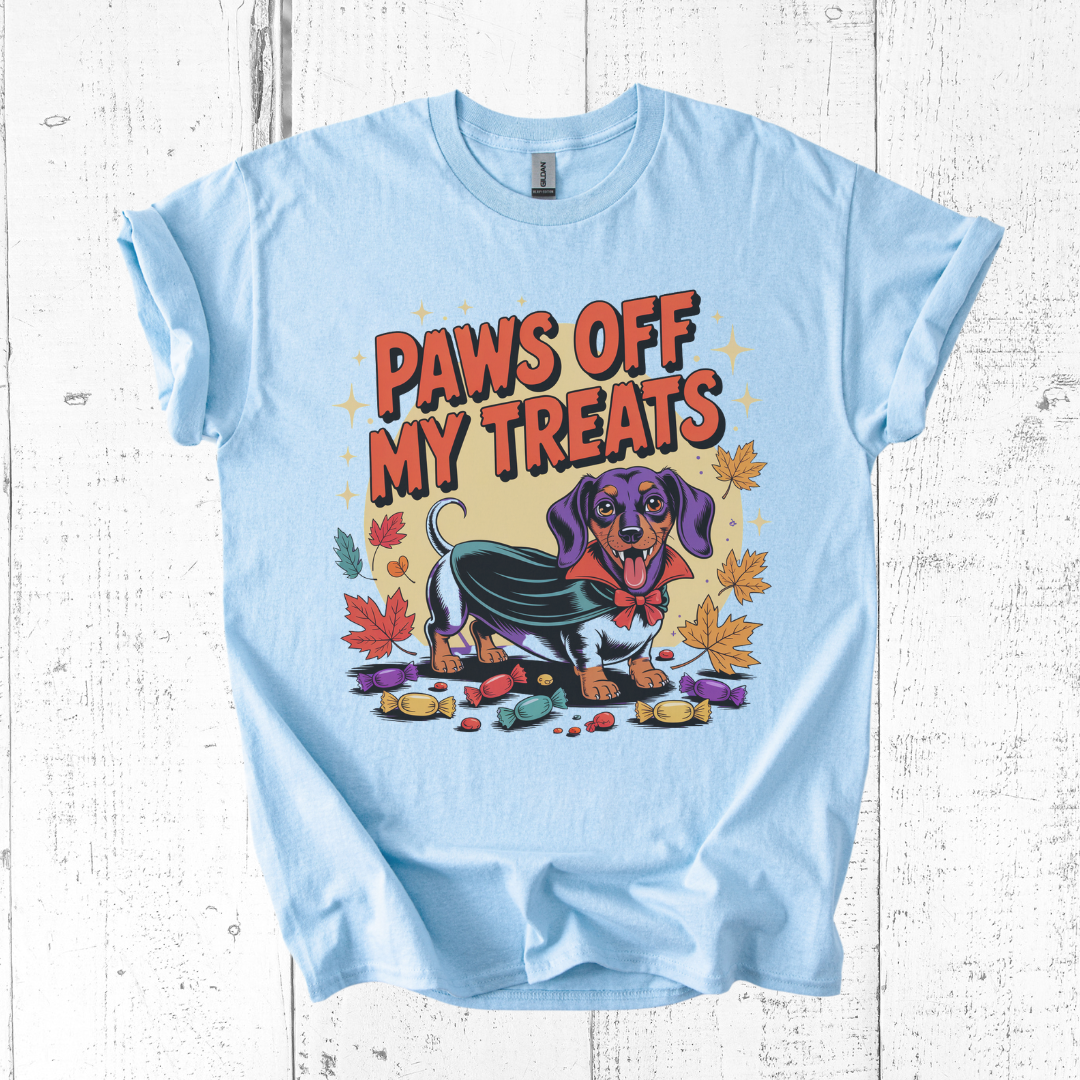Light blue t-shirt with a dachshund graphic and 'Paws Off My Treats' text on a wooden surface