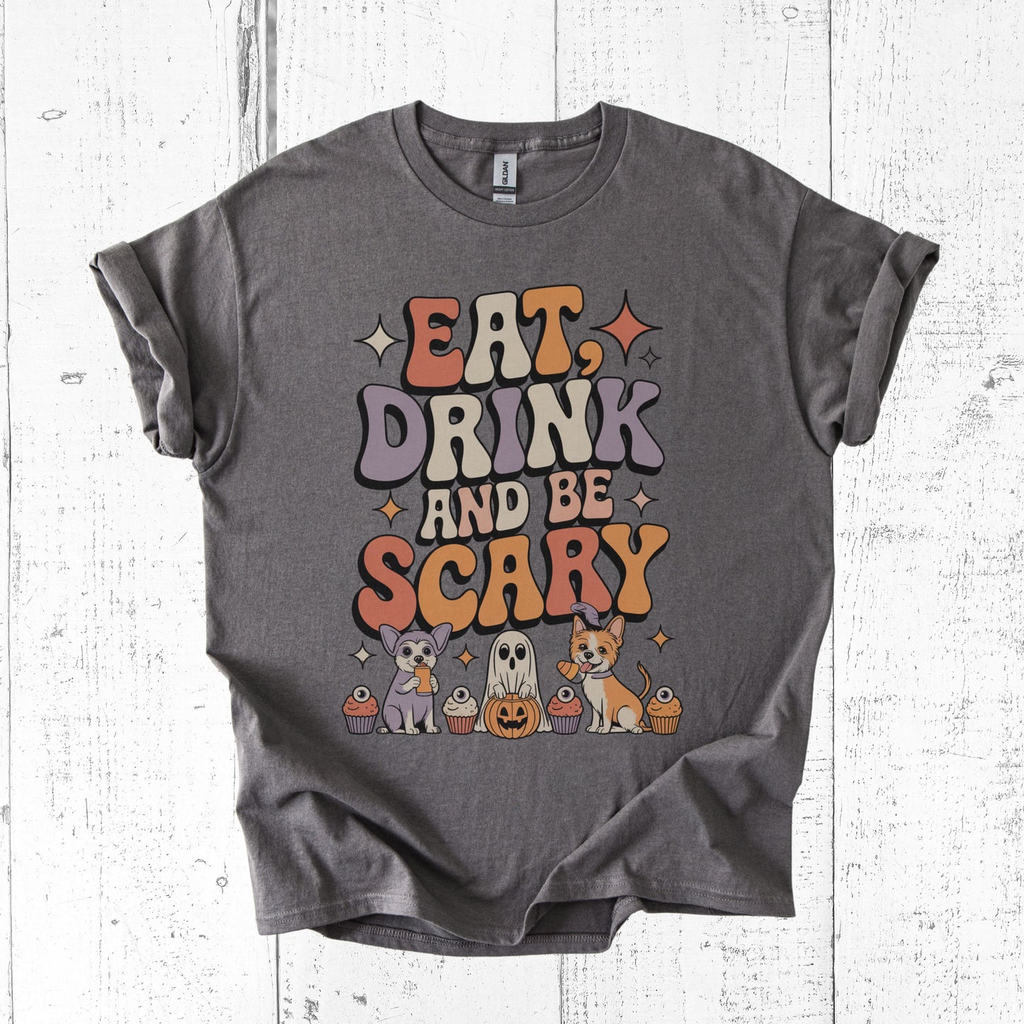 Gray t-shirt with Halloween-themed design on a white wooden surface