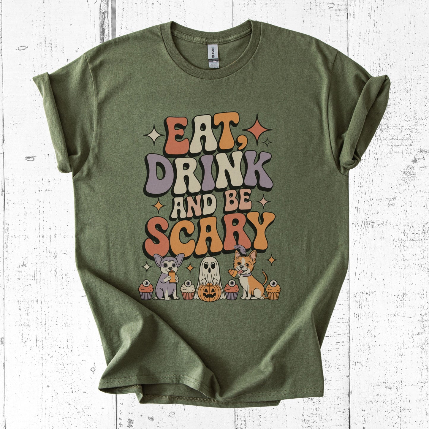 Green t-shirt with Halloween-themed text and graphics on a white wooden background