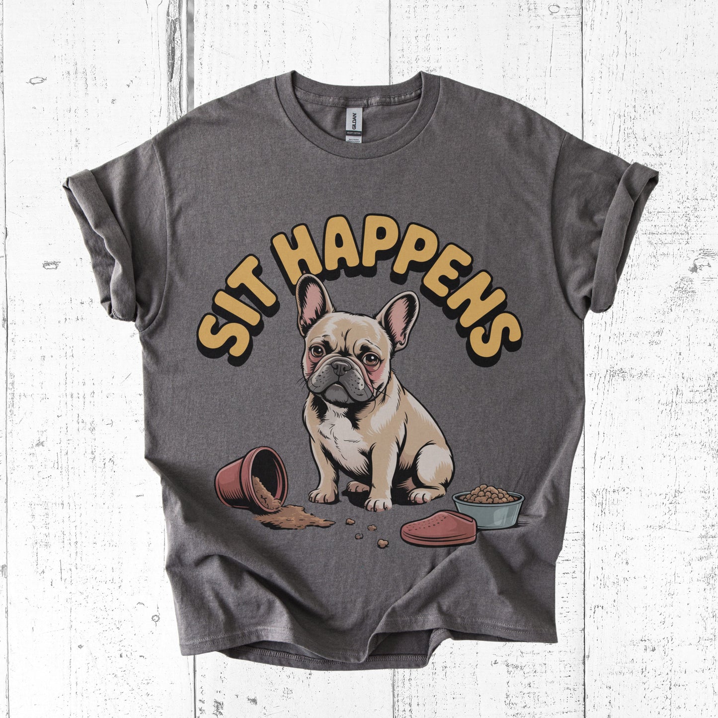 Gray t-shirt with a dog graphic and 'SIT HAPPENS' text on a white wooden surface