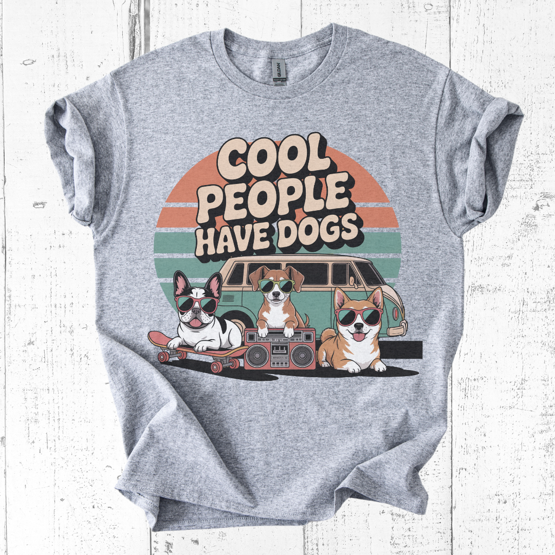 Gray t-shirt with 'Cool people have dogs' graphic design on a white wooden background