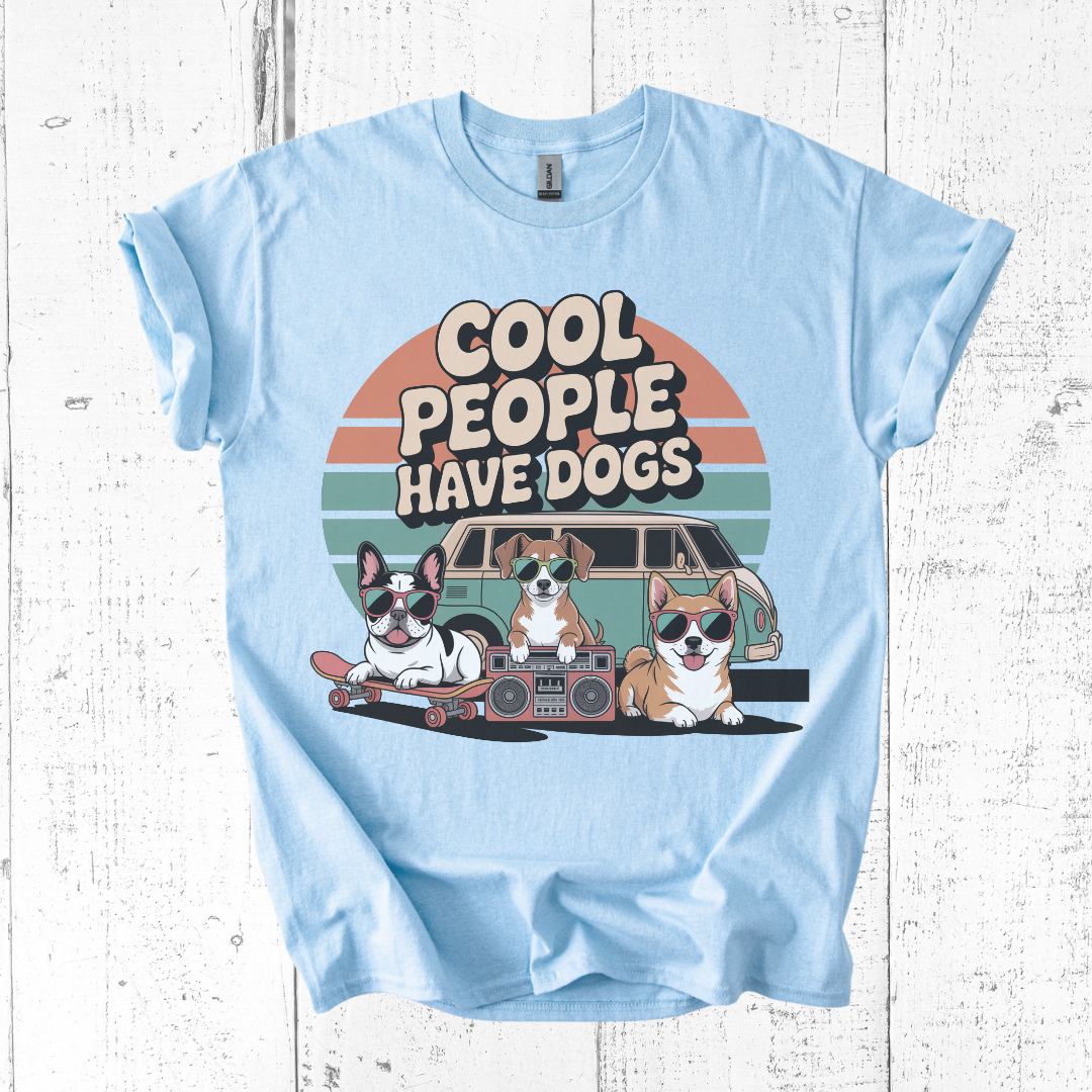 Light blue t-shirt with 'Cool people have dogs' graphic on a wooden surface
