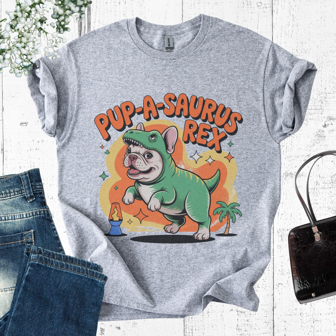Gray t-shirt with 'Pup-A-Saurus Rex' graphic design on a white wooden surface with jeans and a handbag.