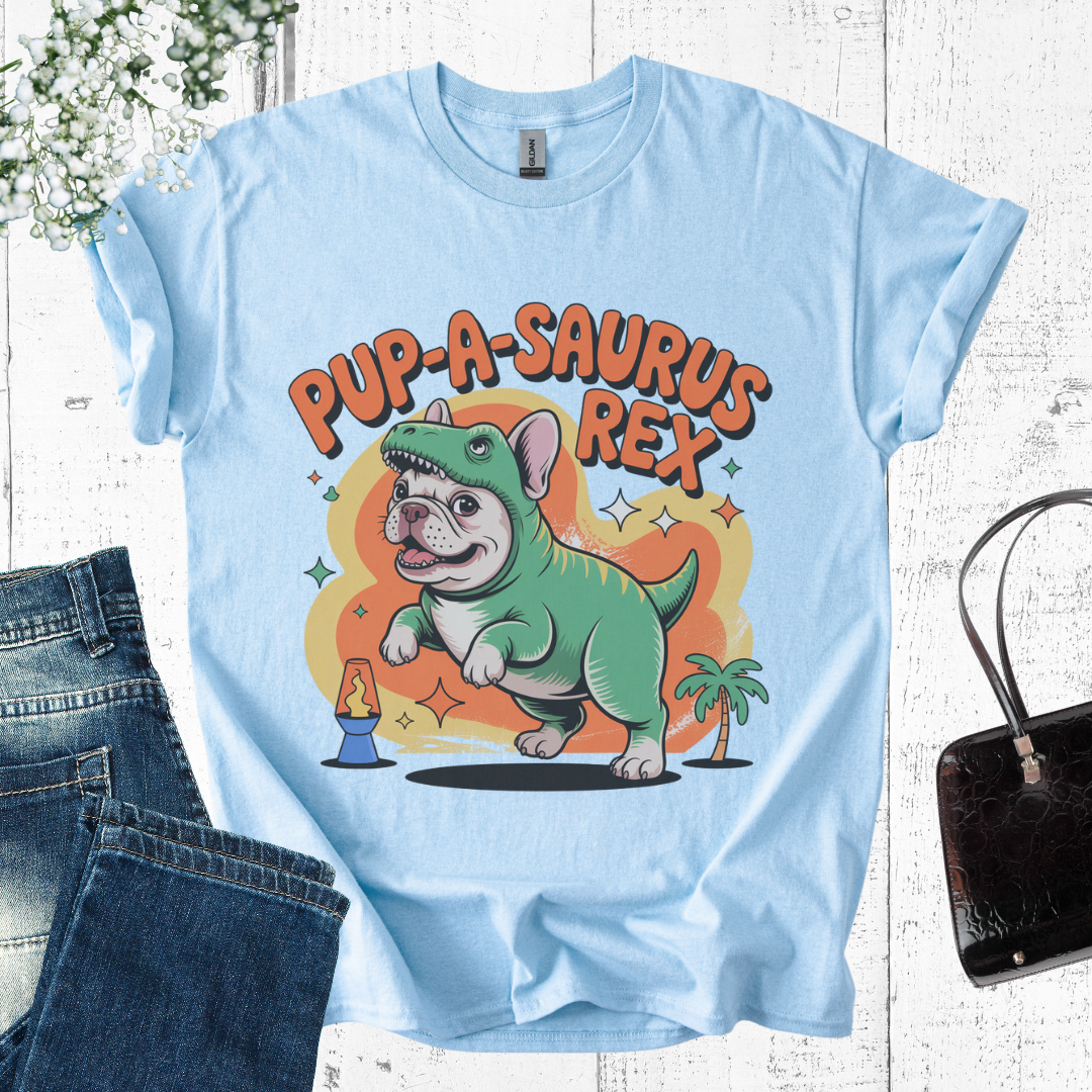 Light blue t-shirt with a cartoon dog dinosaur hybrid design on a wooden surface.