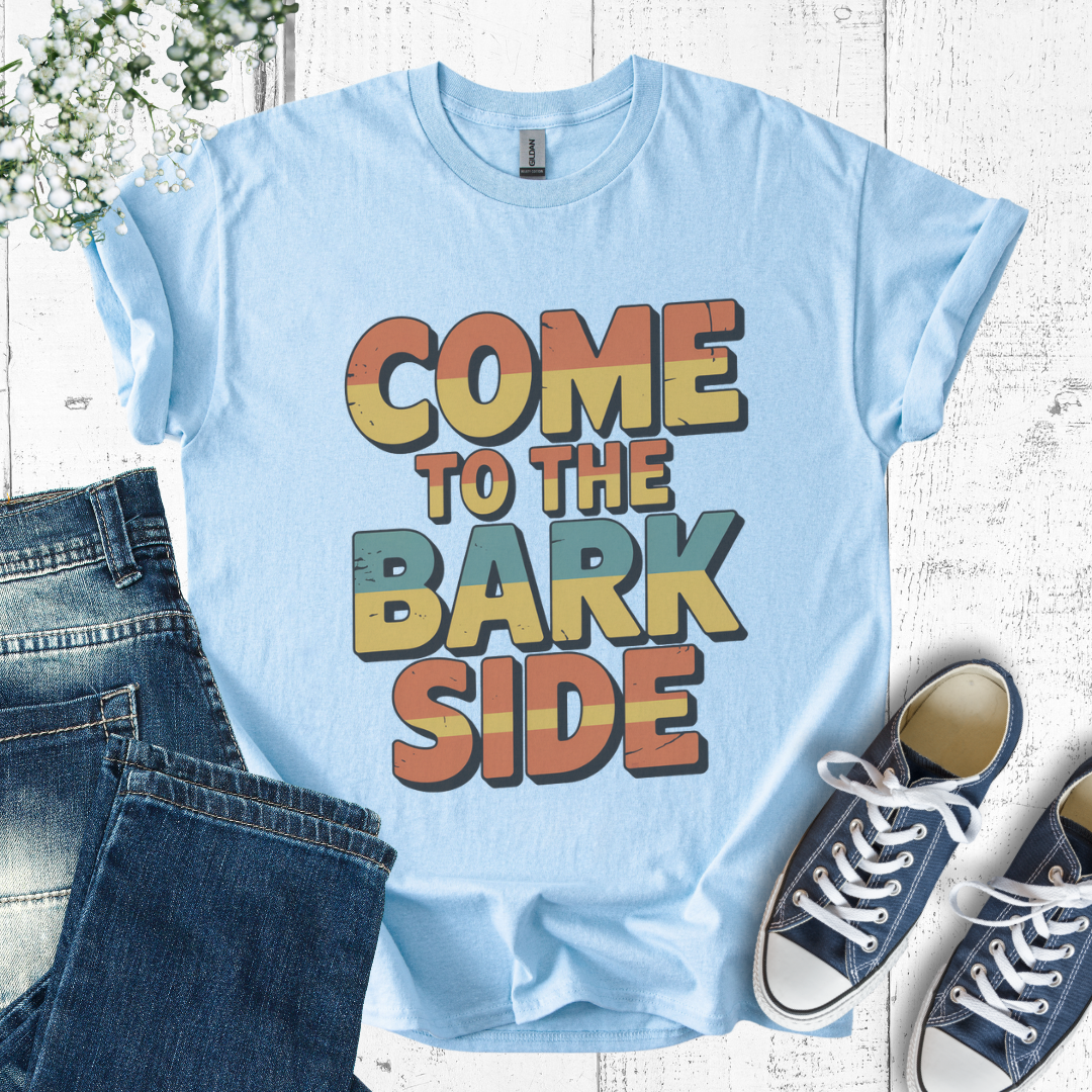 Light blue t-shirt with 'Come to the Bark Side' text, paired with jeans and sneakers on a wooden surface.