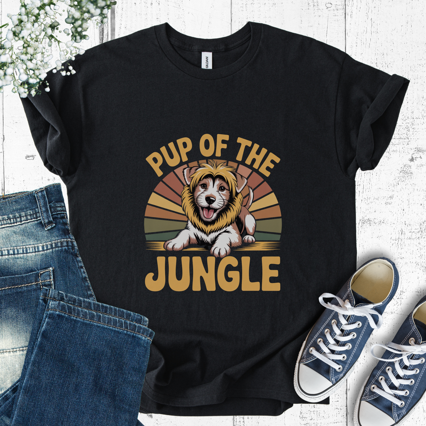 Black t-shirt with 'Pup of the Jungle' design featuring a dog in a lion costume, placed on a white surface with jeans and sneakers.