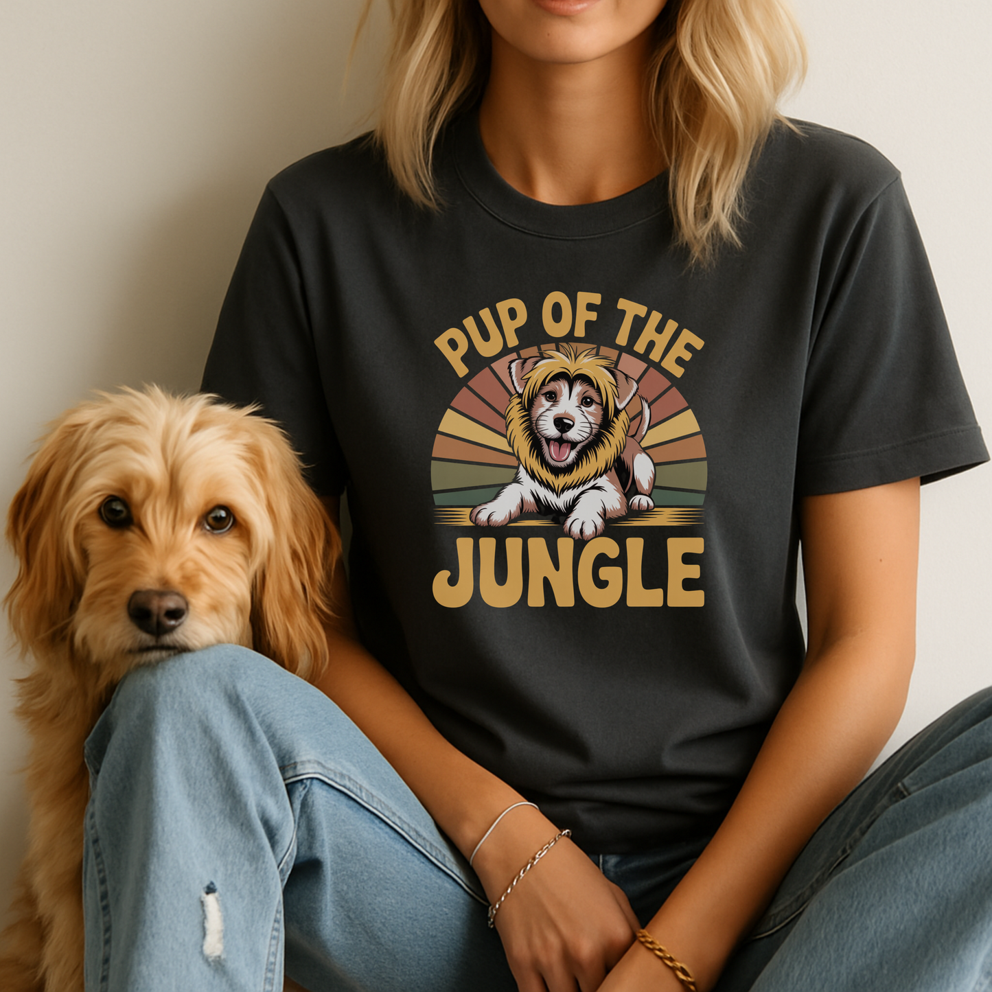 Person wearing a black t-shirt with 'Pup of the Jungle' graphic and a dog sitting next to them.