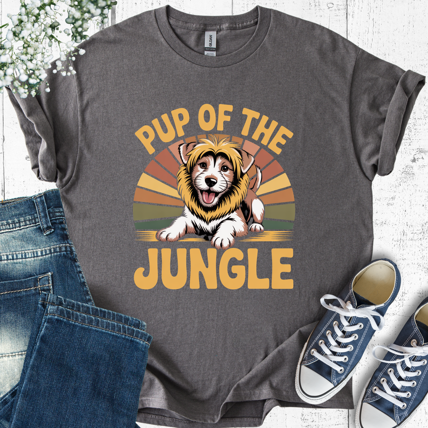 Gray t-shirt with 'Pup of the Jungle' design featuring a dog in a lion costume, paired with jeans and sneakers on a light wooden surface.
