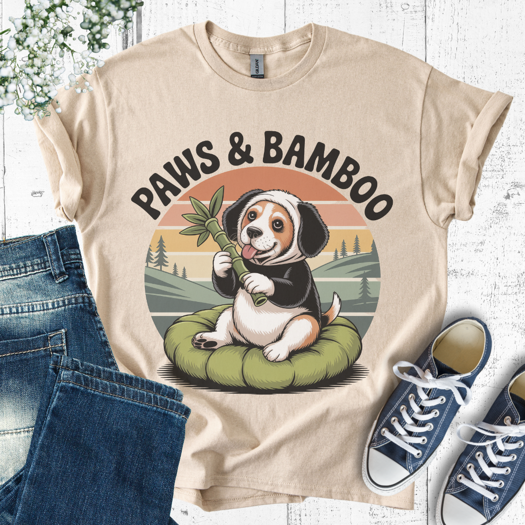 Beige t-shirt with a dog holding a bamboo stick graphic and 'Paws & Bamboo' text, displayed with jeans and sneakers.