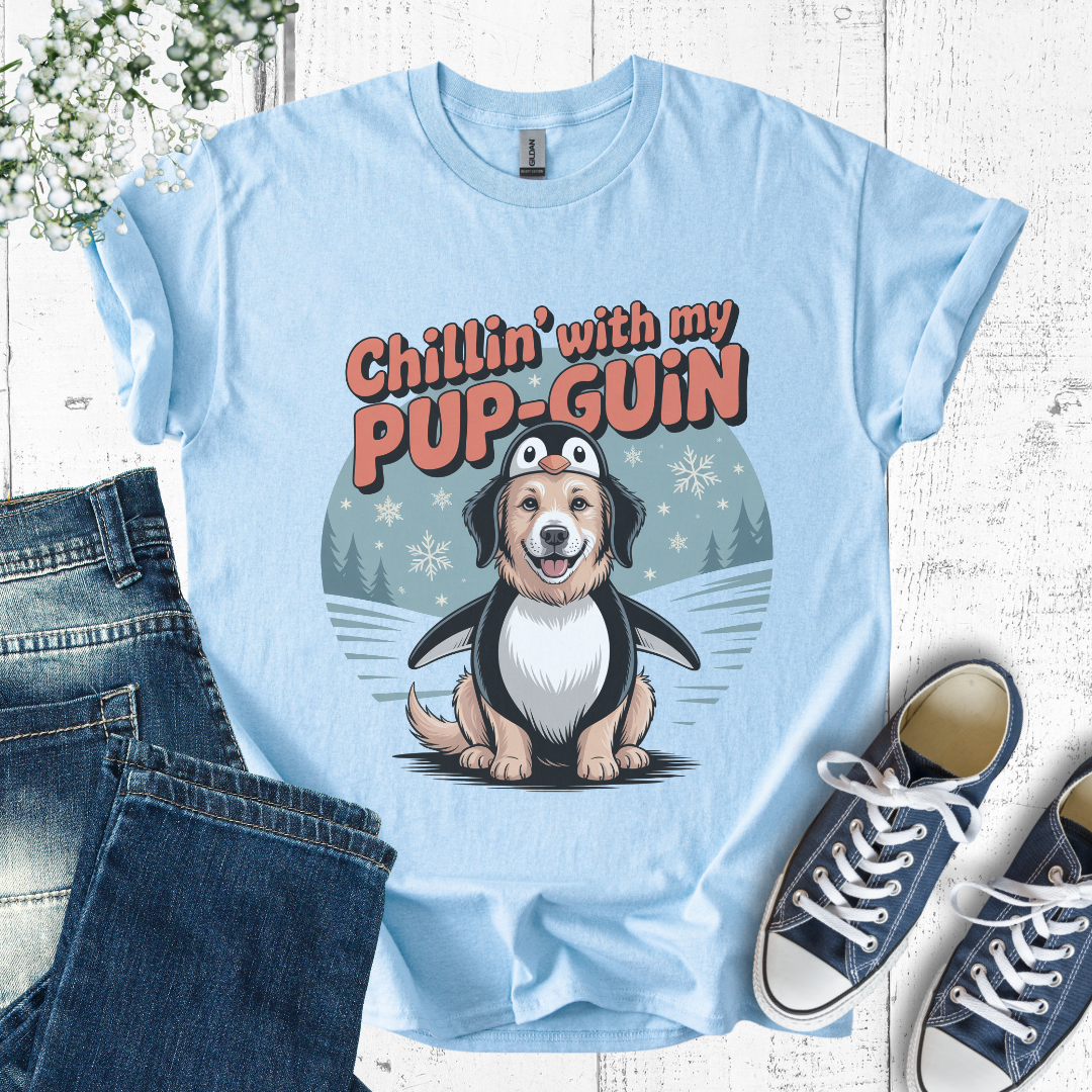 Light blue t-shirt with a cartoon penguin and dog design, text 'Chillin' with my PUP-GUIN', displayed with jeans and sneakers.