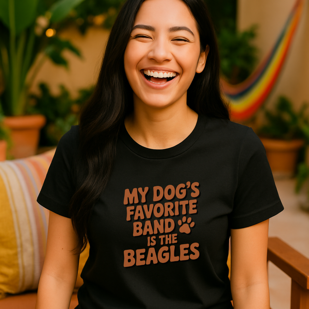 Woman wearing a black t-shirt with 'My dog's favorite band is the beagles' text, laughing outdoors.