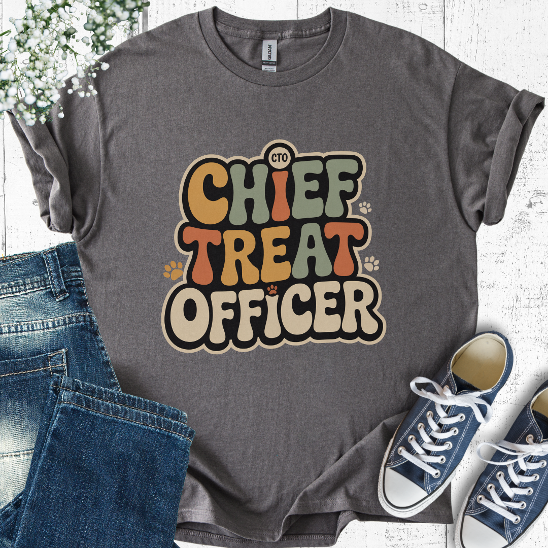Gray t-shirt with 'Chief Treat Officer' text, paired with jeans and sneakers on a light wooden surface.