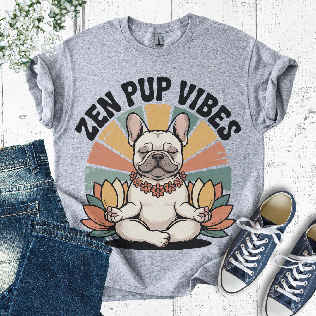 Gray t-shirt with 'Zen Pup Vibes' design featuring a dog in a meditative pose, placed on a white surface with jeans and sneakers.