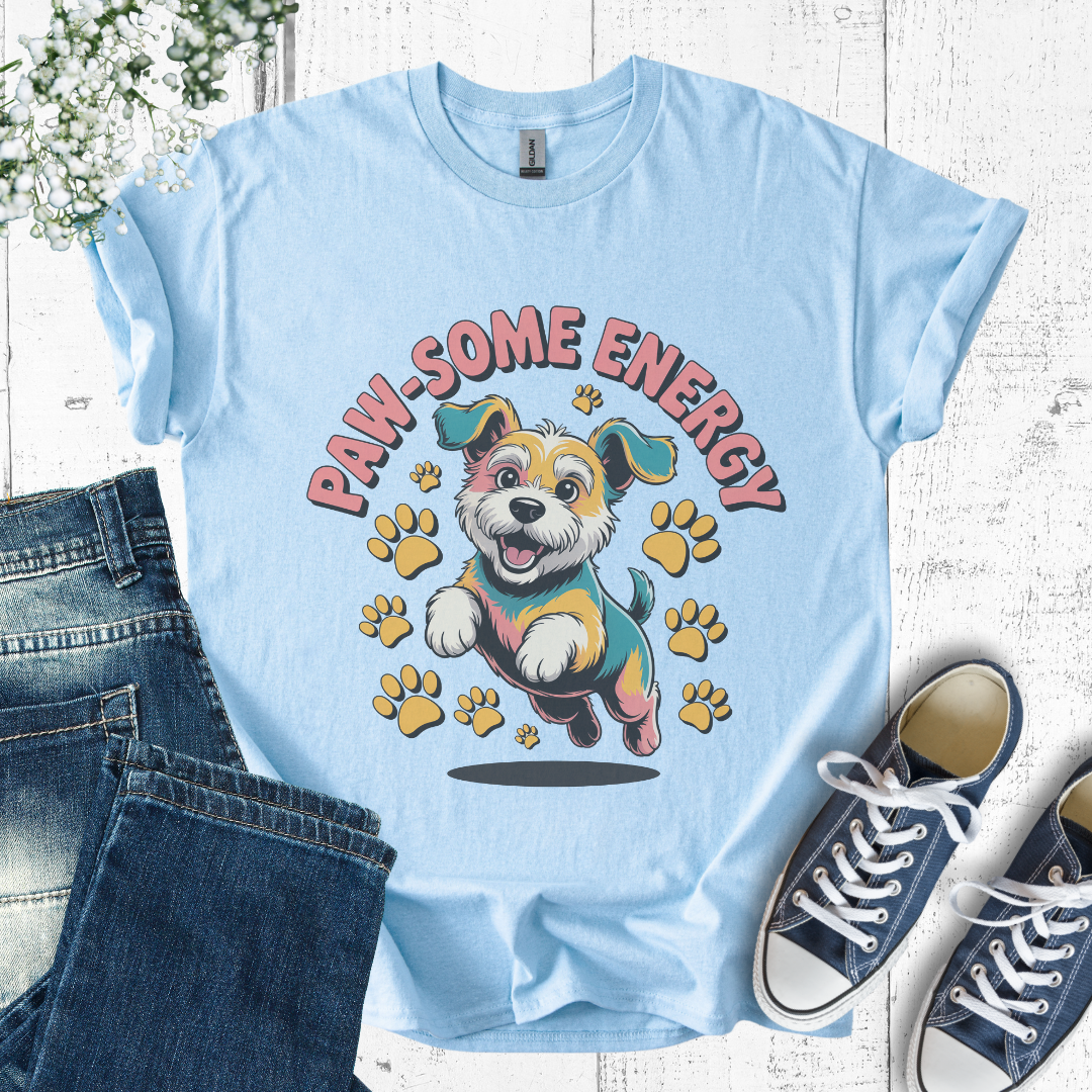Light blue t-shirt with a cartoon dog and 'PAW-SOME ENERGY' text, paired with jeans and sneakers on a wooden surface.
