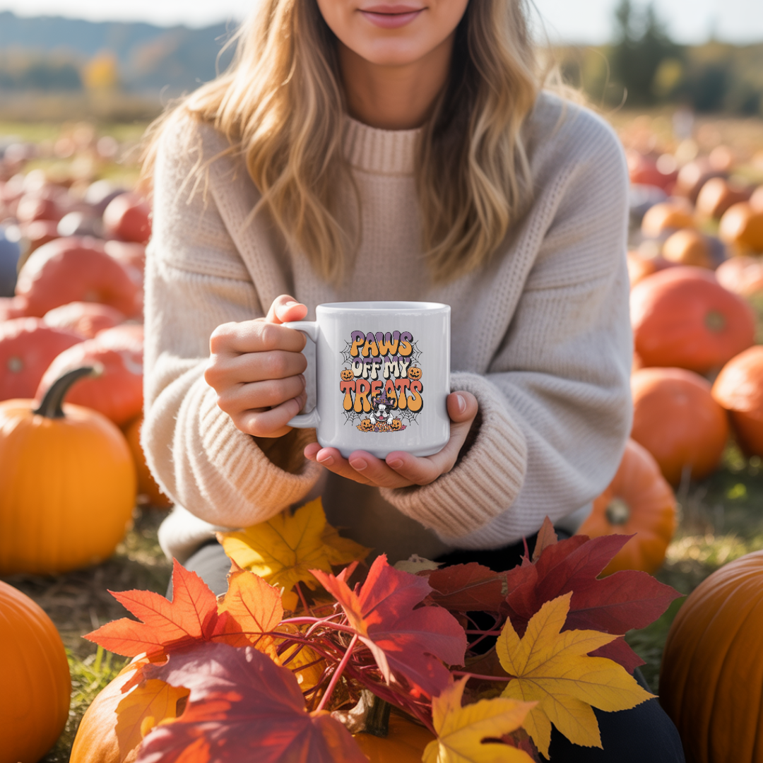Person holding a mug with a pumpkin patch background