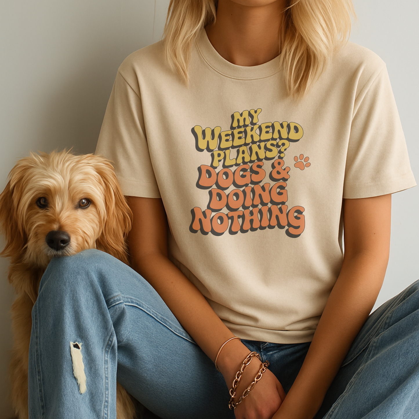 Person wearing a t-shirt with 'My weekend plans? Dogs & doing nothing' text sitting next to a dog.