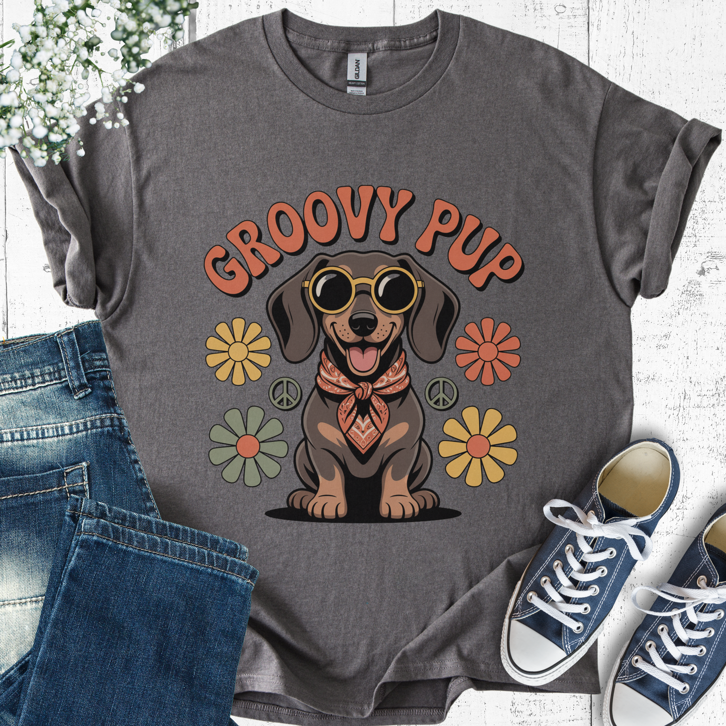 Gray t-shirt with 'Groovy Pup' design featuring a dog, flowers, and peace signs, displayed with jeans and sneakers.