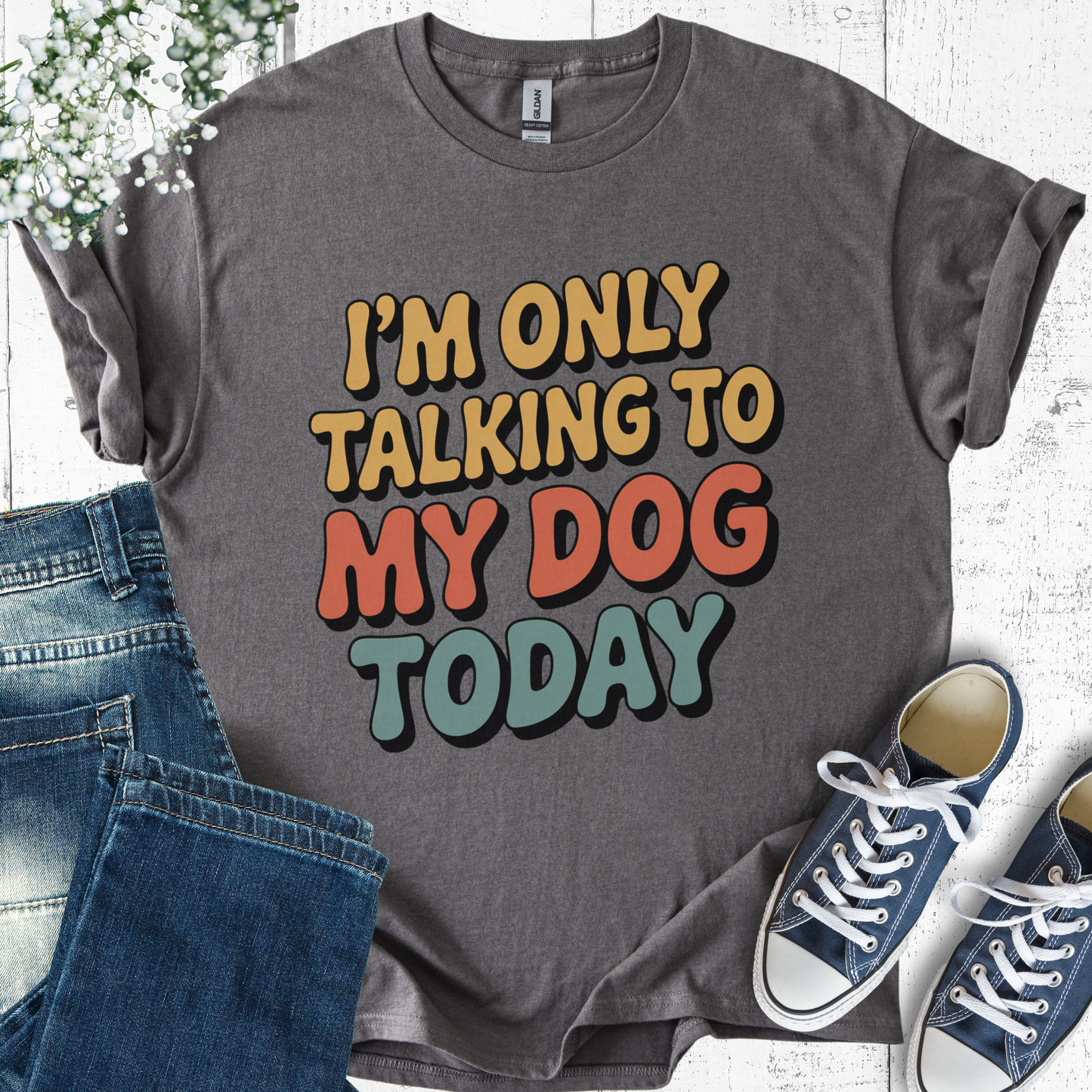 Gray t-shirt with colorful text 'I'm only talking to my dog today' on a white background with jeans and sneakers.
