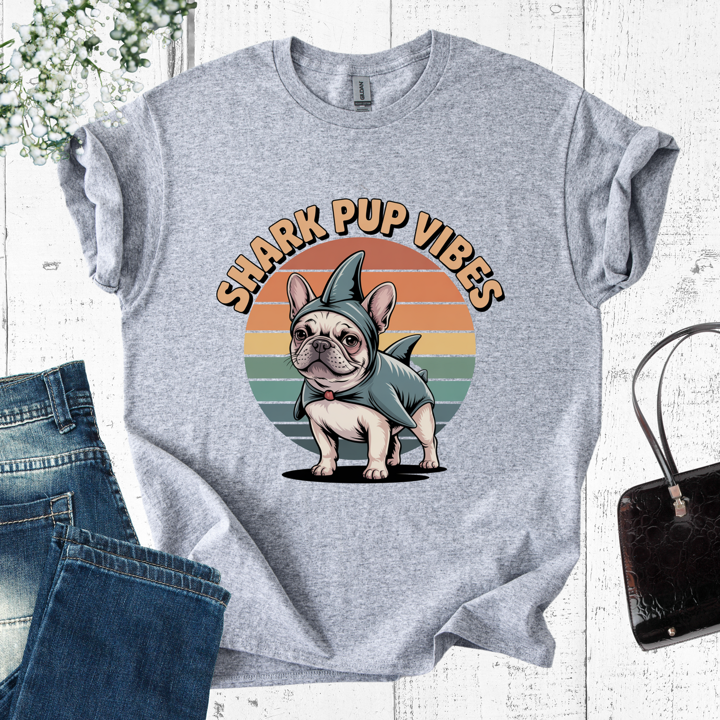 Gray t-shirt with a dog in a shark costume graphic and 'Shark Pup Vibes' text, displayed with jeans and a handbag.