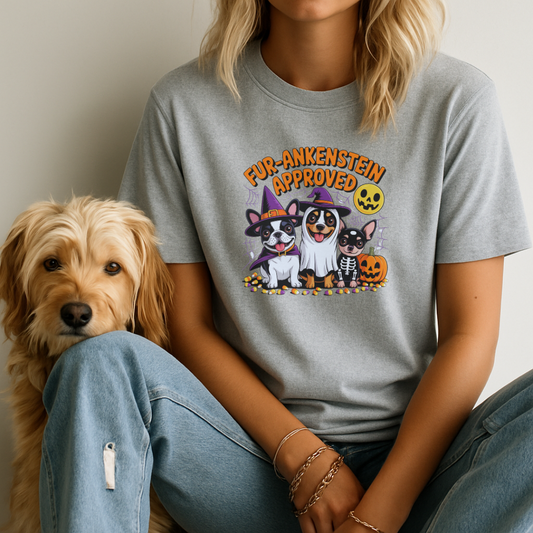 Person wearing a gray t-shirt with Halloween-themed design sitting next to a dog.
