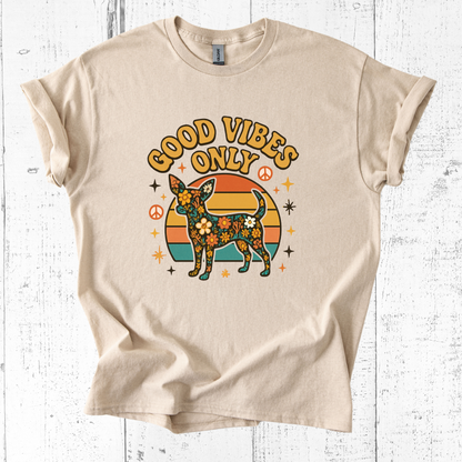 Beige t-shirt with a dog graphic and 'Good Vibes Only' text on a white wooden background