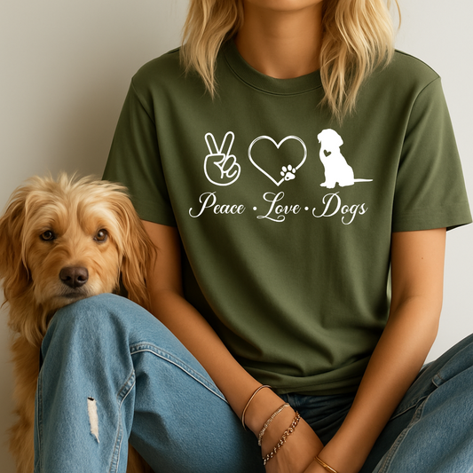 Person wearing a green t-shirt with 'Peace Love Dogs' design sitting next to a dog.