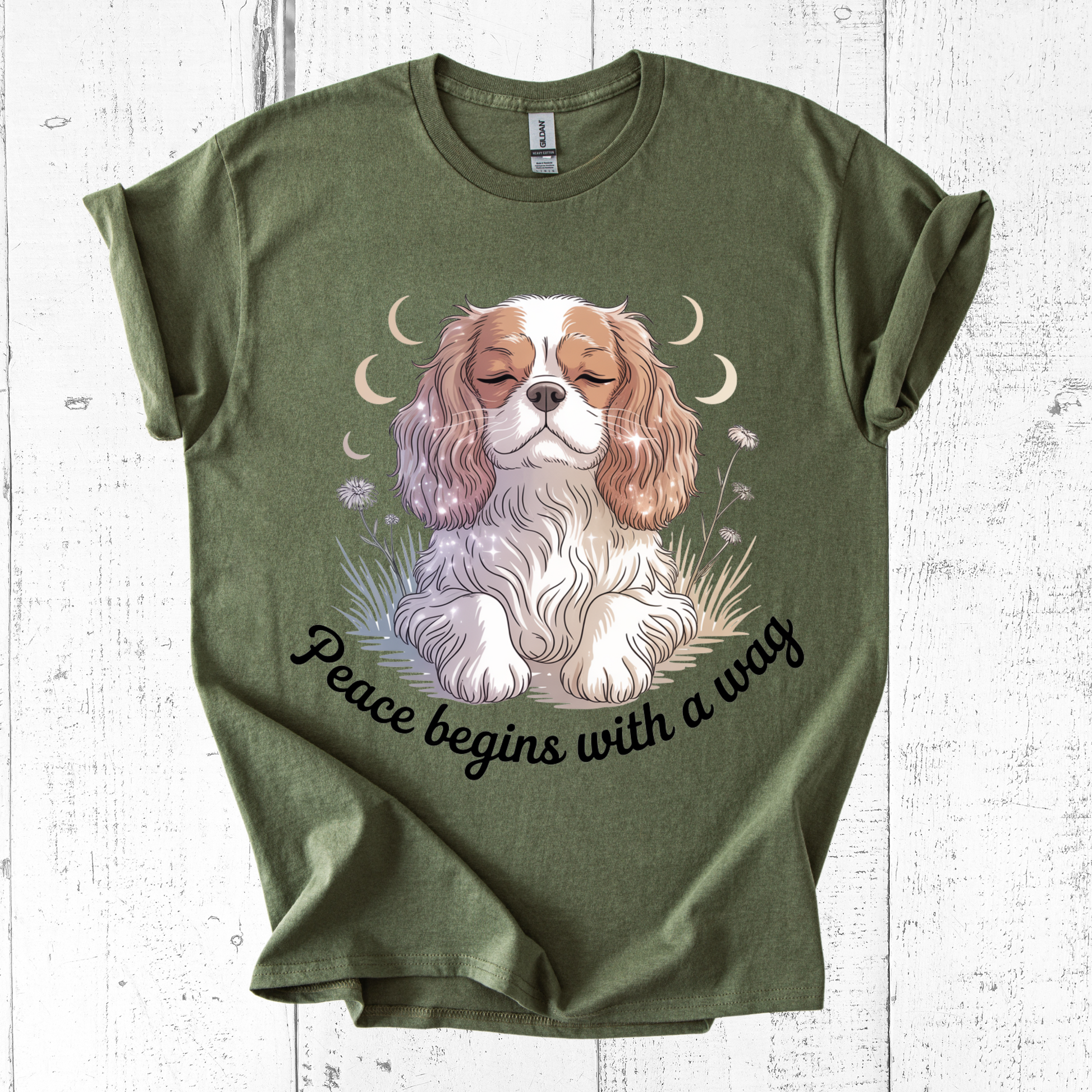 Green t-shirt with a dog graphic and 'Peace begins with a wag' text on a white wooden surface