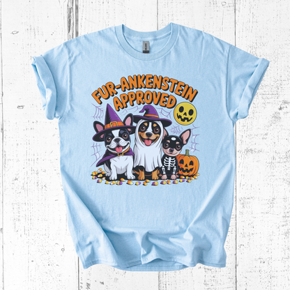 Light blue t-shirt with Halloween-themed design featuring dogs and text on a wooden surface.
