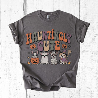 Gray t-shirt with Halloween-themed graphics and 'Hauntingly Cute' text on a white wooden background