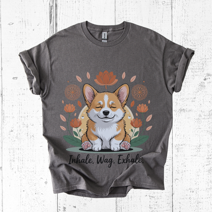 Gray t-shirt with a corgi graphic and 'Inhale. Wag. Exhale.' text on a white wooden background