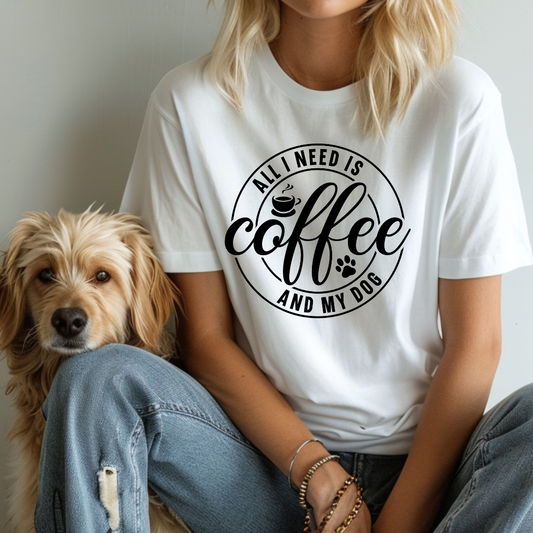 Person wearing a white t-shirt with 'All I Need is Coffee and My Dog' text, sitting next to a dog.