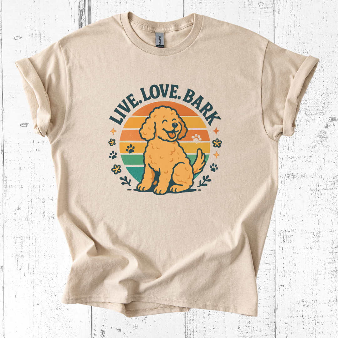 Beige t-shirt with a dog graphic and 'Live, Love, Bark' text on a white wooden background